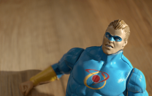 animated super hero action figure lying on hardwood floor